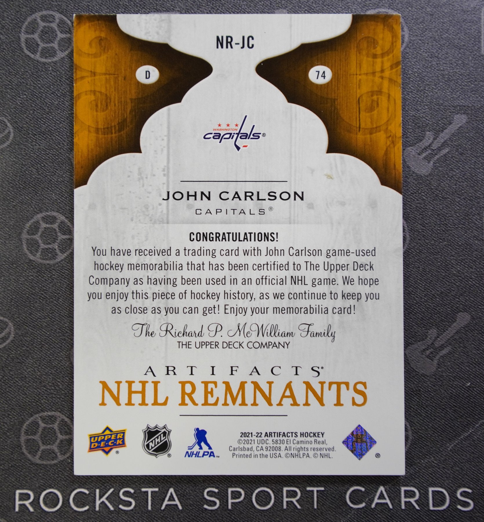 Оборотная сторона карточки John Carlson — 2021/22 Upper Deck Artifacts — NHL Remnants — #NR-JC
