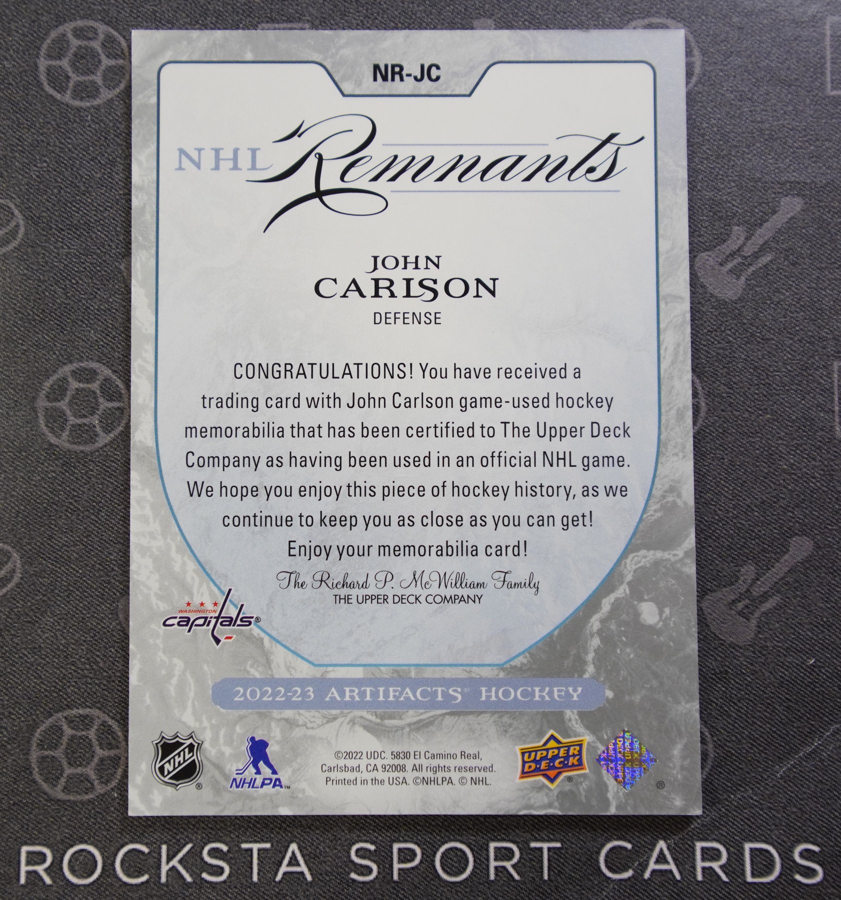 Оборотная сторона карточки John Carlson — 2022/23 Upper Deck Artifacts — NHL Remnants — #NR-JC